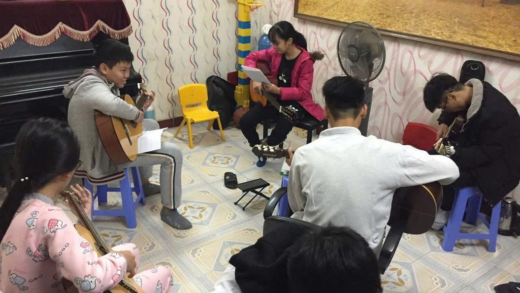 Nhóm học viên luyện guitar Nhóm học viên luyện guitar cùng nhau trong câu lạc bộ