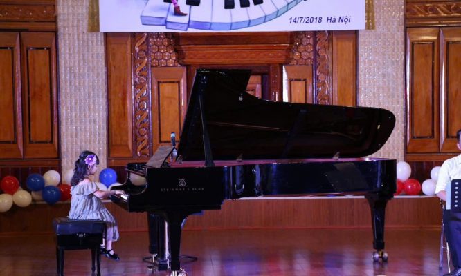 Bé mới học piano biểu diễn trên sân khấu trong chương trình âm nhạc thiếu nhi