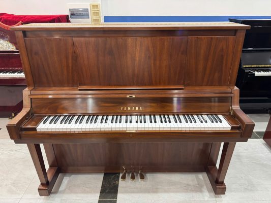 Đàn piano Yamaha W102 vân gỗ đặt tại showroom giúp người mua quan sát trực tiếp trước khi chọn đàn