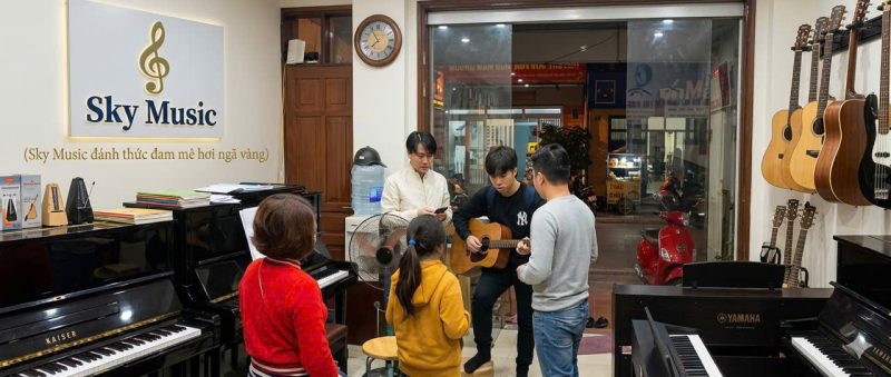 Học viên nhỏ đang luyện piano trong không gian Sky Music với nhiều đàn piano trưng bày thực tế