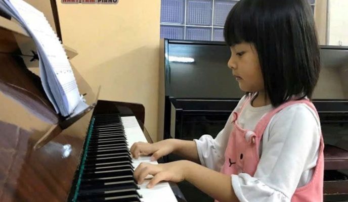 Bé luyện tập piano tại nhà trong giai đoạn đầu với tư thế và kỹ thuật đúng