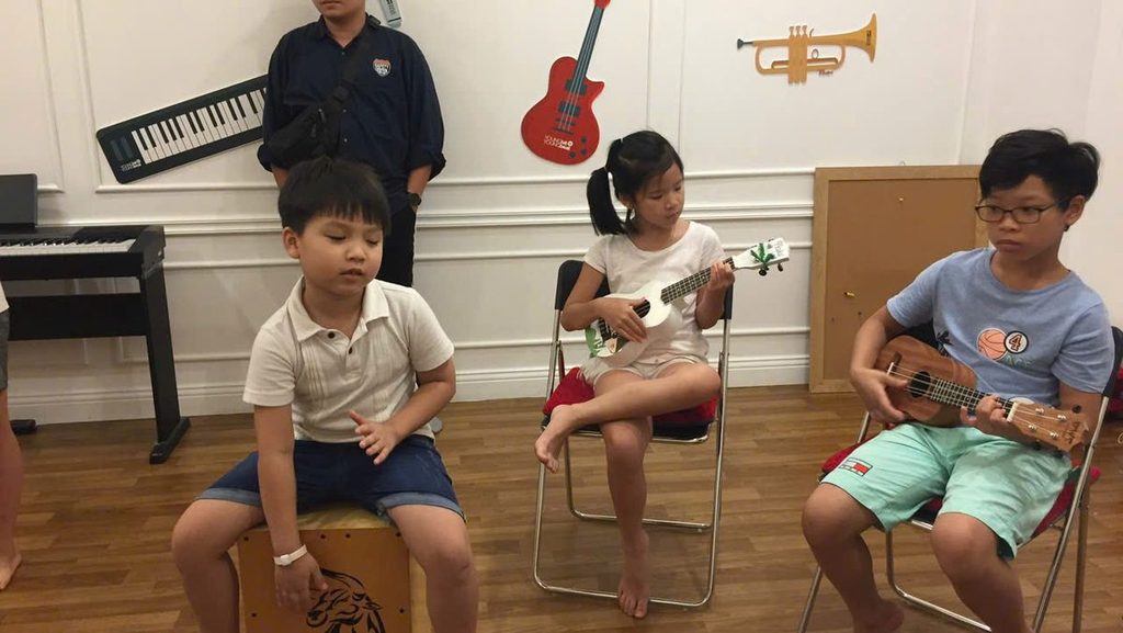 Trẻ em luyện nhịp với nhạc cụ dây và trống cajon